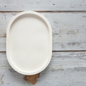 Beltéri gipsz kiegészítő: egy kisméretű, ovális alakú, matt tálca peremmel. A minimalista design tökéletessé teszi ékszertartónak vagy kulcsok tárolására, vagy dekorációnak, rusztikus fa felületen fotózva.