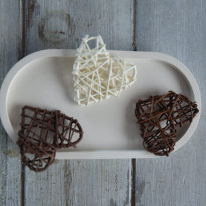 Beltéri gipsz dekoráció: egy közepes méretű, ovális alakú matt tálca. A megemelt perem és a letisztult forma ideálissá teszi parfümök, nagyobb gyertyák vagy fürdőszobai kiegészítők esztétikus rendszerezéséhez.