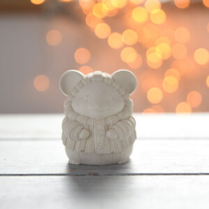 Profilból fotózott gipsz egérke figura piros bogyós ággal és ünnepi kiegészítőkkel, tökéletes karácsonyi dekoráció.