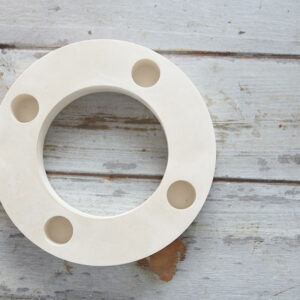 Felülnézeti fotó egy kör alakú, négy férőhelyes gipsz adventi gyertyatartó alapról rusztikus fa felületen.